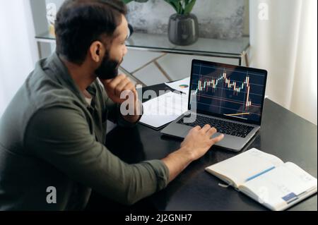 Laptop-Bildschirm mit Aktiendiagrammen. Krypto-Trader-Investor-Broker, der Laptop für die Kryptowährung-Finanzmarktanalyse, den Kauf oder Verkauf von Kryptowährung, die Planungsstrategie verwendet Stockfoto