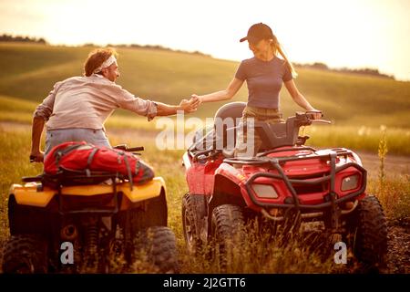 Menschen in der Natur.Quad Bike in den Bergen.Mann und lächelndes Mädchen fahren Off-Road und genießen auf extremen Reiten Stockfoto