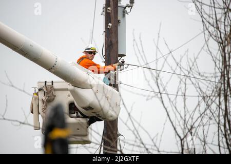 Bedminster, Usa. 01. April 2022. Ein Linienarbeiter repariert Stromleitungen, nachdem Gewitter schwere Schäden an Häusern und Eigentum in der Gegend verursacht und Strom 150 Häuser am Freitag, 01. April 2022 in Bedminster, Pennsylvania, ausgeschlagen hat. Der nationale Wetterdienst untersucht, ob ein Tornado tatsächlich angerührt wurde und die Ursache des Schadens war. Kredit: William Thomas Cain/Alamy Live Nachrichten Stockfoto