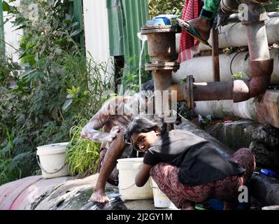 Neu-Delhi, Indien. 01. April 2022. Eine Familie wäscht und badet am 1. April 2022 bei heißem Wetter in Neu-Delhi, Indien, in Leckwasser aus einer Pipeline. (Foto: Ravi Batra/Sipa USA) Quelle: SIPA USA/Alamy Live News Stockfoto