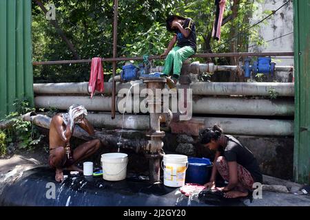 Neu-Delhi, Indien. 01. April 2022. Eine Familie wäscht und badet am 1. April 2022 bei heißem Wetter in Neu-Delhi, Indien, in Leckwasser aus einer Pipeline. (Foto: Ravi Batra/Sipa USA) Quelle: SIPA USA/Alamy Live News Stockfoto