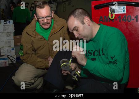 220401-N-GP384-1054 IONISCHES MEER (1. April 2022) Master Chief Avionics Joseph Becker, links, aus Waterloo, Iowa, Und Aviation Structural Mechanic 1. Class Toby Lauck, aus St. Louis, beide zugewiesen an die 'Drachenschüler' des Helicopter Sea Combat Squadron (HSC) 11, Lackierung auf MH-60s Sea Hawk Hubschrauberbrückenkomponenten in der Hangarbucht des Nimitz-Klasse Flugzeugträgers Harry S. Truman (CVN 75), 1. April 2022. Die Harry S. Truman Carrier Strike Group ist im Rahmen eines geplanten Einsatzes im Bereich der Sechsten Flotte der USA im Einsatz, um die Interessen der USA, der Alliierten und der Partner in Europa und zu unterstützen Stockfoto