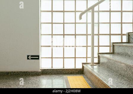 Granitfliesen auf dem Gebäude mit Glasblöcken und taktilen Fußböden auf dem Boden Stockfoto