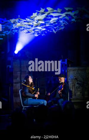 Edinburgh, Schottland. Fr, 1. April 2022. Piper Brìghde Chaimbeul und Fiddler-Spieler Aidan O'Rourke treten im Rahmen des Burns & Beyond Festivals live in der St. Giles' Cathedral auf. Das Konzert fand unter Michael Pendrys Kunstinstallation ‘Les Colombes (The Doves)’ statt, einer geschwungenen Säule aus mehr als 2.500 Origami-Papiertauben, die die gesamte Länge der Kathedrale durchfliegen. Stockfoto