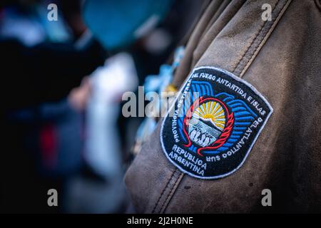 Ushuaia, Argentinien. 01. April 2022. „Tierra del Fuego, Antarktische und Südatlantische Inseln - Argentinische Republik“, liest ein Wappen auf der Jacke eines Kriegsveteranen während eines Gedenkens an den 40.. Jahrestag des Starts des Falklandkrieges. Die Falklandinseln werden seit 1833 von Großbritannien regiert. Im Jahr 2022 erneuerte der argentinische Präsident Fernandez den Anspruch des südamerikanischen Landes auf das britische Überseegebiet. Quelle: Joel Reyero/dpa/Alamy Live News Stockfoto