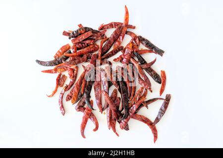 Geröstete chilli de Arbol auf einer weißen Oberfläche; Paprika annum; mexikanischer Pfeffer zum Kochen und Zubereiten von Salsa und Saucen. Stockfoto