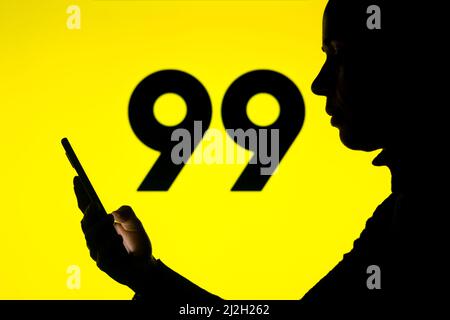 Brasilien. 01. April 2022. In dieser Fotobilder hält die Silhouette einer Frau ein Smartphone mit dem 99 App-Logo im Hintergrund. Kredit: SOPA Images Limited/Alamy Live Nachrichten Stockfoto