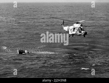 Ein Hubschrauber der US-Küstenwache Sikorsky HH-52A Seaguard über die Raumkapsel Gemini 3, die von den Astronauten Gus Grissom und John Young geflogen wurde, nachdem sie am 23. März 1965 im Atlantischen Ozean niedergespritzt war. Der Flugzeugträger USS Intrepid (CVS-11) erholte das Schiff und die Besatzung. Stockfoto