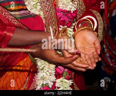 Traditionelle bengalische hinduistische Hochzeitszeremonie, Bräutigam hält Hand in Hand der Braut. Selektiver Fokus Stockfoto