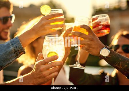 Am Ende ist alles, was zählt, Glück. Eine kurze Aufnahme einer Gruppe von nicht erkennbaren Freunden, die einen Drink zu sich nehmen und den Tag auf dem Dach verbringen. Stockfoto