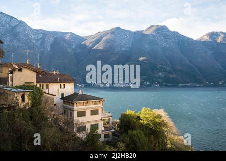 Italien, Como, Häuser am Comer See mit Alpen im Hintergrund Stockfoto