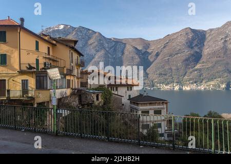 Italien, Como, Häuser am Comer See mit Alpen im Hintergrund Stockfoto