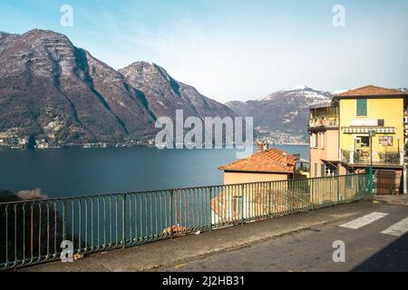 Italien, Como, Häuser am Comer See mit Alpen im Hintergrund Stockfoto