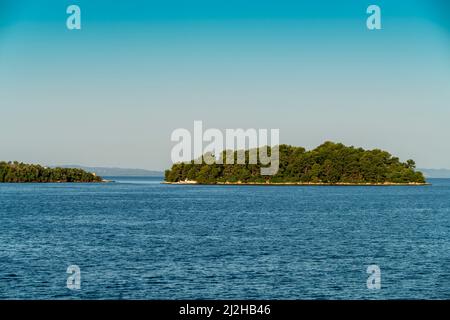 Griechenland, Igoumenitsa, kleine grüne Insel im Meer Stockfoto