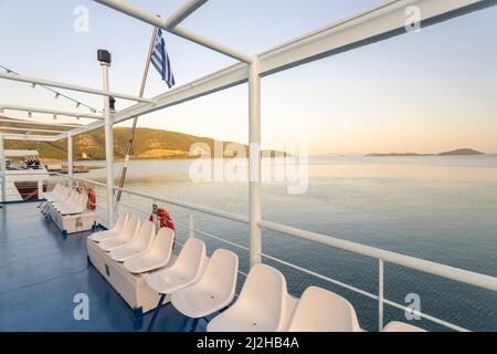 Griechenland, Igoumenitsa, Sitzreihe auf dem Fährendeck im Meer bei Sonnenaufgang Stockfoto