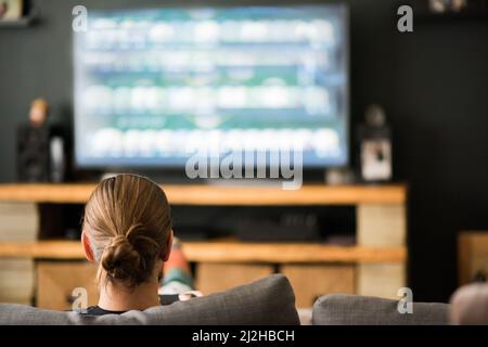 Rückansicht des Mannes, der zu Hause ein Videospiel spielt Stockfoto