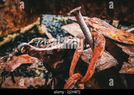 Nahaufnahme eines Nagels mit einer rostigen Kette, der auf einem verschwommenen Hintergrund in Island hängt Stockfoto