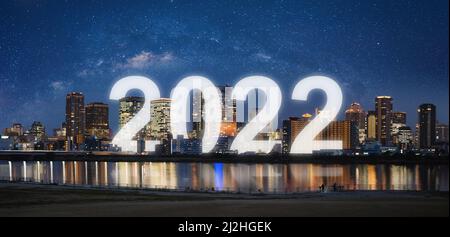 Neujahr 2022 in der Stadt. Panorama-Stadt bei Nacht mit Sternenhimmel und glücklichen Neujahr 2022 Feiern Stockfoto