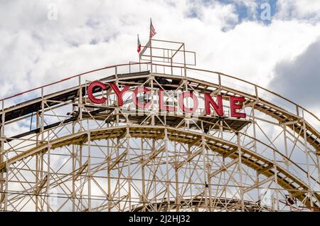 Cyclone Wooden Rollercoaster Rotes Logo auf der Oberseite des Achterbahners mit amerikanischer und italienischer Flagge, Coney Island, Brooklyn Luna Park Amusement Park, New Y Stockfoto