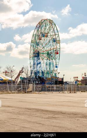 Wonder Wheel, Ferris Wheel im Luna Park Amusement Park, Coney Island, Brooklyn, Blick von der Seite, Strand und Zaun vor dem Hotel, New York City bei Sonne Stockfoto