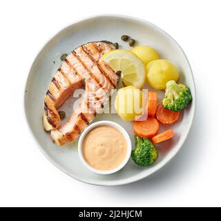 Platte mit gegrilltem Lachssteak und Gemüse isoliert auf weißem Hintergrund, Draufsicht Stockfoto