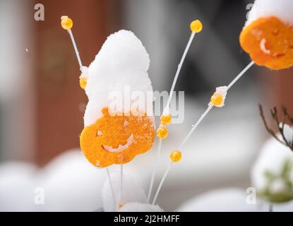 02. April 2022, Hessen, Frankfurt/Main: Mit Schnee bedeckt ist eine Dekoration aus Filz aus dem letzten Halloween in einem Vorgarten, nachdem es am Vortag und in der Nacht geschneit hatte. Foto: Frank Rumpenhorst/dpa Stockfoto