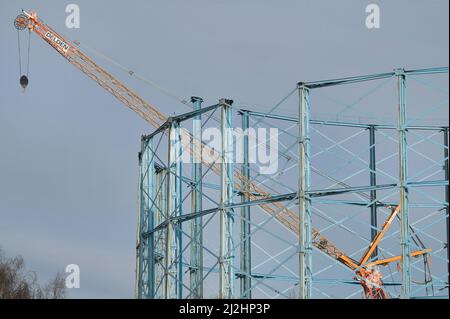 Birmingham, England, April 2. 2022. Die Arbeiten zur Demontage der drei ungenutzten Gashalter in der Windsor Street in Birmingham laufen derzeit. Die Stahlkonstruktionen am Standort Nechells wurden zuletzt im Jahr 2012 verwendet, da Verbesserungen am Gasübertragungssystem bedeuten, dass Gas jetzt im Rohrsystem unterirdisch gespeichert werden kann. Das Gaswerk beherbergte einst 11 Gashalter und als die Zwillingsgashalter 1885 gebaut wurden, waren sie die größten der Welt. Das ikonische Wahrzeichen wurde erstmals 1980s in den Farben des örtlichen Fußballvereins Aston Villa gestrichen. Es wird angenommen, dass der Techniker einmal für die Wartung verantwortlich war Stockfoto