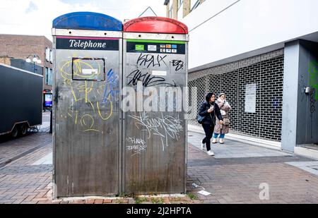 Kingston upon Thames London, Großbritannien, 01 2022. April, zwei öffentliche Telefonzellen, die mit Graffiti-Farbe mit Pappel bedeckt sind, die vorbeigehen Stockfoto