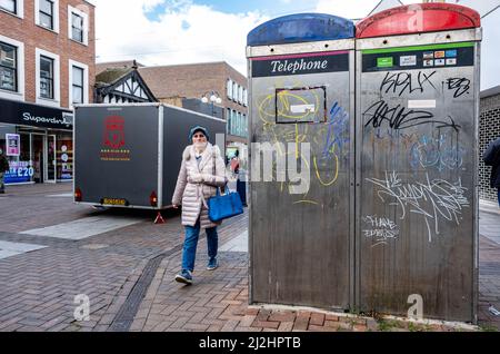 Kingston upon Thames London, Großbritannien, 01 2022. April, zwei öffentliche Telefonzellen, die mit Graffiti-Farbe mit Pappel bedeckt sind, die vorbeigehen Stockfoto