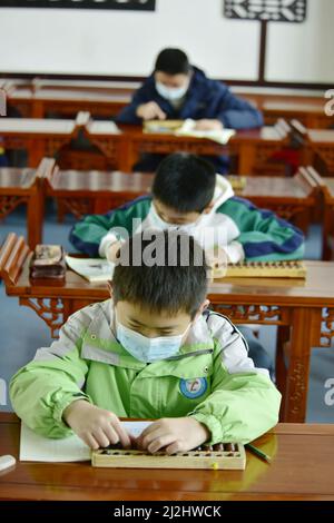 HEFEI, CHINA - 2. APRIL 2022 - Kinder aus einer Grundschulklasse nehmen an einem Abacus-Kopfrechnen-Wettbewerb für autistische Kinder Teil Stockfoto