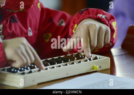 HEFEI, CHINA - 2. APRIL 2022 - Kinder aus einer Grundschulklasse nehmen an einem Abacus-Kopfrechnen-Wettbewerb für autistische Kinder Teil Stockfoto