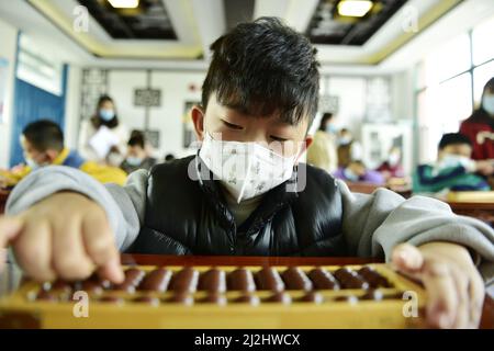 HEFEI, CHINA - 2. APRIL 2022 - Kinder aus einer Grundschulklasse nehmen an einem Abacus-Kopfrechnen-Wettbewerb für autistische Kinder Teil Stockfoto