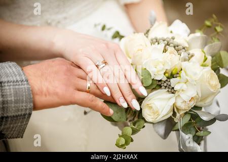 Verheiratete Hände mit goldenen Ringen Stockfoto