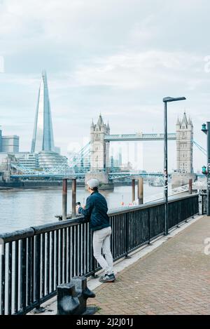 Blick nach Westen auf die Londoner Tower Bridge und den Shard von einem Aussichtspunkt auf dem Themse Path neben der Alderman Stairs und St. Katherine's Way Stockfoto