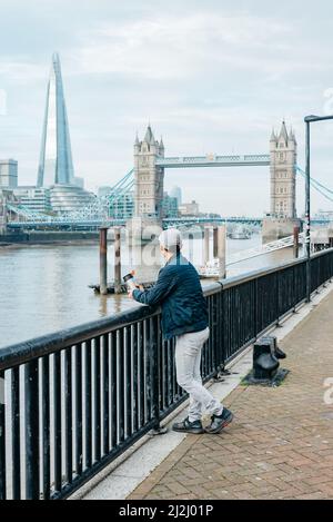 Blick nach Westen auf die Londoner Tower Bridge und den Shard von einem Aussichtspunkt auf dem Themse Path neben der Alderman Stairs und St. Katherine's Way Stockfoto