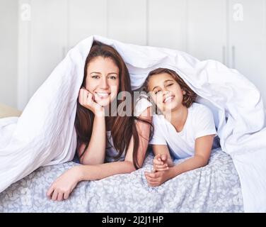 Nur in unserer Decke Fort entspannen. Portrait einer Mutter und Tochter, die sich morgens zu Hause entspannen. Stockfoto