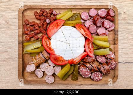 Holzbrett mit Fleischstücken, blauem Käse und Gemüse, auf der Küchentheke, Draufsicht. Stockfoto