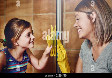 Es ist nur sauber, wenn wir uns klar sehen können. Eine kurze Aufnahme einer Mutter und ihrer kleinen Tochter, die zu Hause gemeinsam ein Badezimmer putzen. Stockfoto