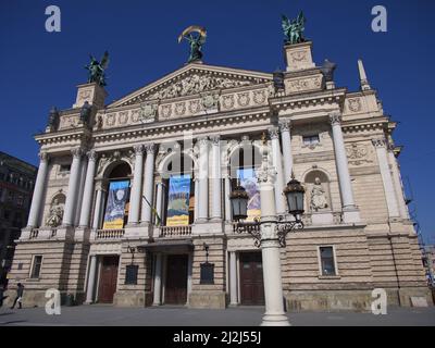 Lviv, Ukraine, 25. März 2022. Solomiya Krushelnytska Lviv Staatliches Akademisches Theater für Oper und Ballett an einem sonnigen Tag. Plakate an der Fassade. Peopl Stockfoto