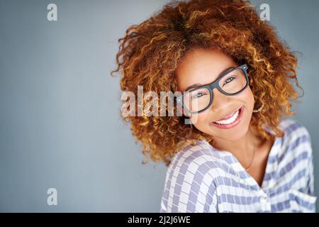 Voller Selbstvertrauen. Studioaufnahme einer jungen Geschäftsfrau vor grauem Hintergrund. Stockfoto