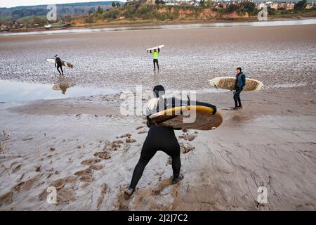 Arlingham, Gloucestershire. Vereinigtes Königreich. 2. April 2022. Surfer trotzen dem kalten Wasser des Flusses Severn in Spring Tide, um die Severn-Bohrung zu erwischen. Ein natürliches Phänomen, das auftritt, wenn die Flut sich gegen den ausströmenden Fluss zurückdrückt und eine Welle erzeugt. Arlingham. Gloucestershire. Vereinigtes Königreich. 2. April 2022. Bild von: Alexander Caminada. Quelle: Alexander Caminada/Alamy Live News Stockfoto