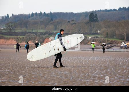 Arlingham, Gloucestershire. Vereinigtes Königreich. 2. April 2022. Peter Mallinson, 74, pensionierter Zoologe. Surfer trotzen dem kalten Wasser des Flusses Severn in Spring Tide, um die Severn-Bohrung zu erwischen. Ein natürliches Phänomen, das auftritt, wenn die Flut sich gegen den ausströmenden Fluss zurückdrückt und eine Welle erzeugt. Arlingham. Gloucestershire. Vereinigtes Königreich. 2. April 2022. Bild von: Alexander Caminada. Quelle: Alexander Caminada/Alamy Live News Stockfoto