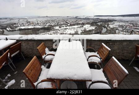 Escherndorf, Deutschland. 02. April 2022. Tische und Stühle eines Ausflugsrestaurants über der Mainschleife sind mit Schnee bedeckt. Quelle: Karl-Josef Hildenbrand/dpa/Alamy Live News Stockfoto