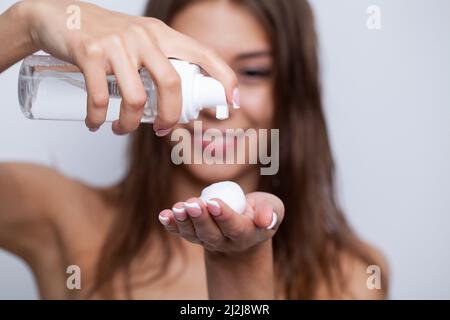 Schöne junge Frau serum Anwendung auf Ihre gesunde lange Haare zu Hause Stockfoto