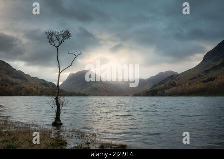 Atemberaubendes Landschaftsbild von Buttermere im Lake District bei Sonnenaufgang im Herbst mit dramatischem stürmischen Himmel Stockfoto
