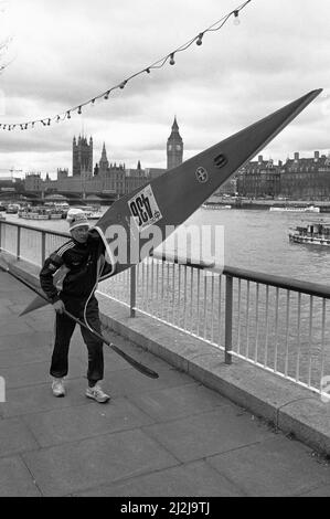 Der Teilnehmer des Kanurennens auf der Themse läuft mit seinem Boot entlang der South Bank, bevor er auf das Wasser geht. 20.. April 1987 Stockfoto