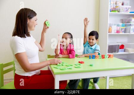 Kinder üben die korrekte Aussprache mit einem Logopädin Stockfoto