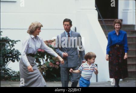 Prinzessin Diana versucht, ihren Sohn William aufzuholen, während Prinz Charles sich bereit macht zu helfen, an dem Tag, an dem Prinz Harry seinen ersten Tag im Kindergarten in Chepstow Villas, West London besucht.Rechts ist Kindergartenlehrerin Jane Mynors. Bild aufgenommen am 16.. September 1987. Stockfoto