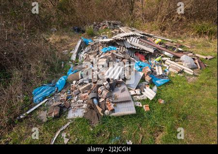 Asbestfolien aus fliegenbestückten Materialien auf Brachland, Abergarwed, Vale of Neath, Wales, Großbritannien Stockfoto