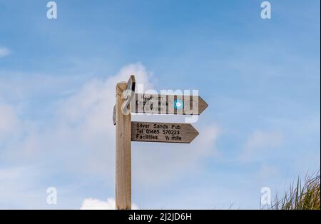 Fingerpost aus Holz mit Blick auf den Heacham Circular Walk und Silver Sands Pub, Heacham, einem Küstendorf im Westen von Norfolk, England, mit Blick auf die Wash Stockfoto